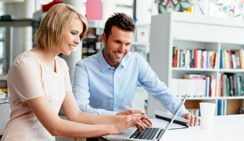 couple on laptop looking for aparment to rent in Grand Cayman