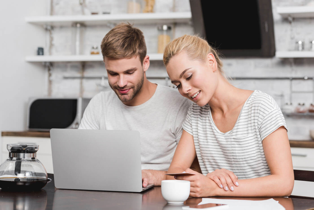 couple sitting by laptop choosing lease grand cayman
