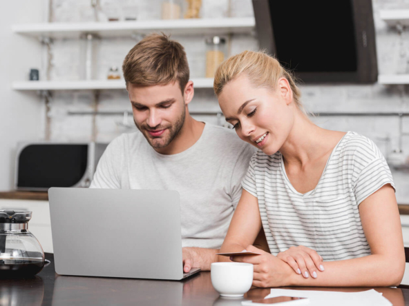 couple sitting by laptop choosing lease grand cayman